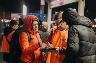 Photo de bénévoles remplissant un questionnaire à coté d'une personne sans-abri