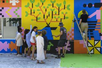Un groupe d'enfants peint sur une fresque murale